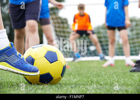 Chiudere fino ai bambini di piedi nella partita di calcio Foto Stock