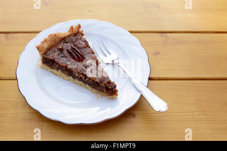 Fetta di appena sfornato torta alle noci pecan su una piastra in Cina con una forcella di dessert Foto Stock