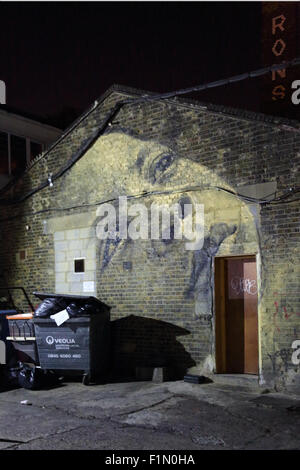 I fantasmi di faccia. Un murale di un volto di donna dipinta sul frontone di un vecchio edificio industriale in Peckham, a sud-est di Londra Foto Stock