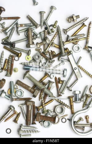 Un mucchio di dadi, bulloni, viti e altri elementi di fissaggio su sfondo bianco Foto Stock