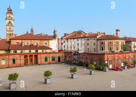 Torre campanaria tra le vecchie case in piccole città di Racconigi in Piemonte, Italia. Foto Stock