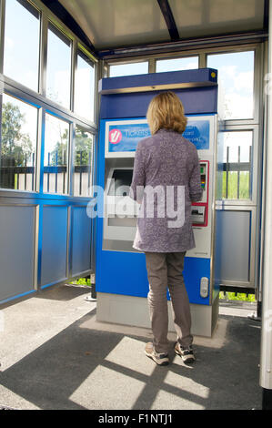 Donna acquisto biglietto ferroviario da un biglietto macchina in corrispondenza di una stazione, REGNO UNITO Foto Stock