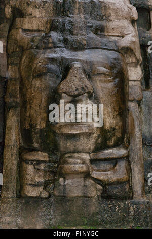 In prossimità di uno stile olmeca faccia che adorna il lato della maschera tempio presso il sito Maya di Lamanai in Belize. Foto Stock
