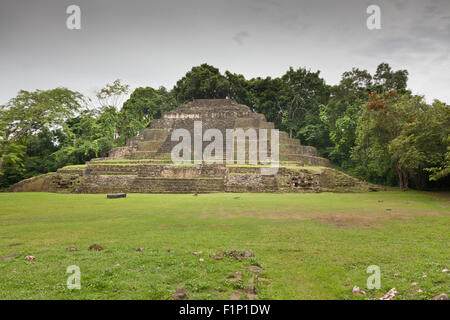 La Jaguar Maya Tempio Piramide con muratura in mattoni che assomigliano a jaguar cat si affaccia su entrambi i lati alla base a Lamanai, il Belize. Foto Stock