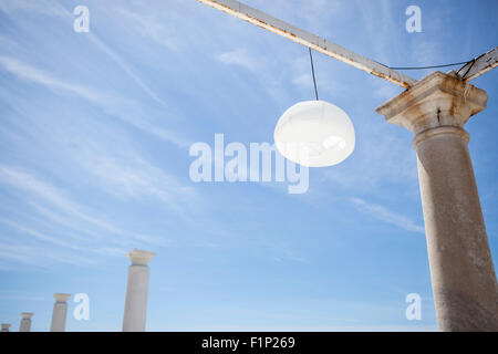 Terrazza accanto al mare con pergola, colonne e lampade di carta una giornata di vento Foto Stock