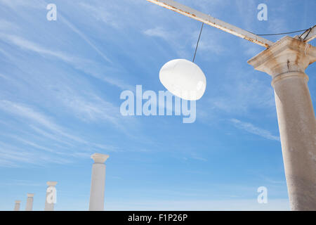 Terrazza accanto al mare con pergola, colonne e lampade di carta una giornata di vento Foto Stock