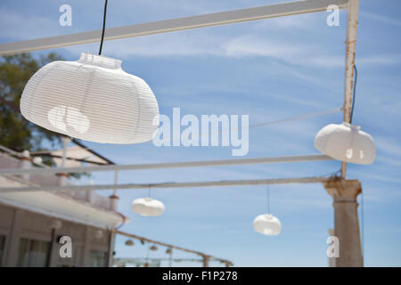 Terrazza accanto al mare con pergola, colonne e lampade di carta una giornata di vento Foto Stock