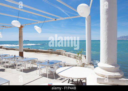 Terrazza accanto al mare con pergola, colonne e lampade di carta una giornata di vento Foto Stock