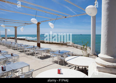 Terrazza accanto al mare con pergola, colonne e lampade di carta una giornata di vento Foto Stock