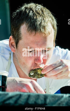 Hillsborough, Irlanda del Nord. 5 settembre 2015 - Un uomo tenta di mangiare 30 ostriche in un minuto a un oyster eating contest Credit: stephen Barnes/Alamy Live News Foto Stock