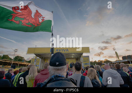 Colwyn Bay, Regno Unito. 5 Settembre, 2015. Uno spettatore sventola la bandiera Gallese come Alex Dowsett (Team Movistar) viene intervistato sul palco del team evento di presentazione prima di Aviva tour della Gran Bretagna presso l'Eirias Stadium, Colwyn Bay, Regno Unito il 5 settembre 2015. La gara inizia il 6 settembre a Beaumaris, Anglesey, e termina il 13 agosto a Londra, Regno Unito. Credito: Andrew Torba/Alamy Live News Foto Stock