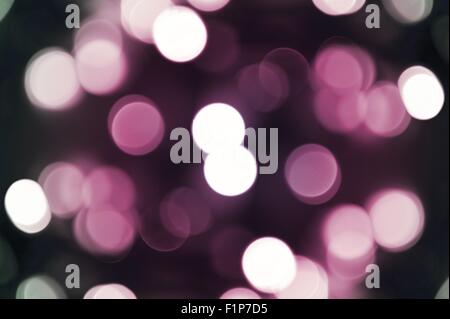 Pinky Bokeh sfondo. Raffreddare fuori fuoco le luci di Natale. Rosa scuro dello sfondo. Foto Stock