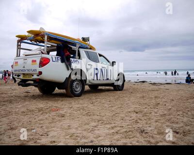 Un RNLI Van con bagnini guarda come surfers brave l'acqua in Cornwall Inghilterra REGNO UNITO Foto Stock