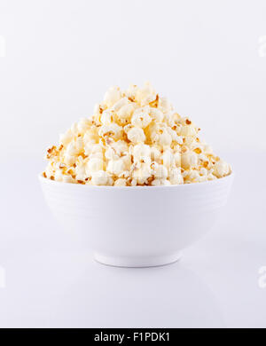 Il Popcorn nella ciotola bianco isolato su sfondo bianco Foto Stock