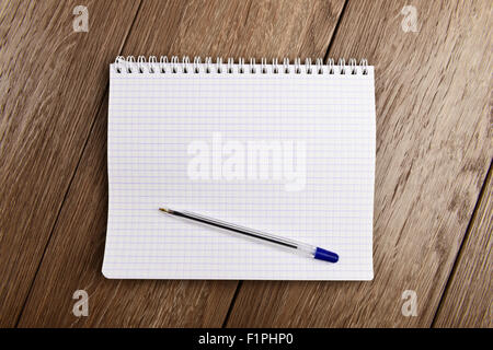 Notebook e penna. Vuoto pagina bianca su sfondo di legno Foto Stock