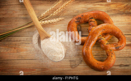 Pane appena sfornato pretzel sul vecchio tavolo in legno. Vista superiore Foto Stock