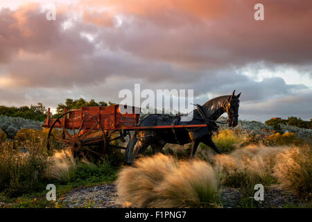 Southport, Merseyside, Regno Unito il 3 settembre, 2015. Regno Unito Meteo. Colorato tramonto sul Mare d'Irlanda e la replica di un cavallo e gamberetti il carrello o il carrello, originariamente utilizzata dagli enti locali shrimpers, che ora è situato sulla saldatura Road Roundabout, adiacente alla riva. Carrelli a cavalli o veicoli meccanici utilizzati per le reti da traino dietro di loro, un metodo di pesca noto come 'shanking'. Foto Stock