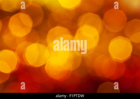 Abstract sfondo sfocato - grande rosso scuro, giallo, marrone scintillanti luci di Natale bokeh di ghirlande su albero di Natale Foto Stock
