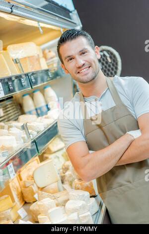 Assistente maschio al contatore di caseificio Foto Stock