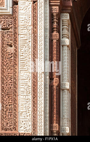 Delhi, India. Qutub Minar complesso. Iscrizioni scolpite in pietra arenaria rossa e marmo sulla porta Alai-Darwaza, in Naskh script. Foto Stock