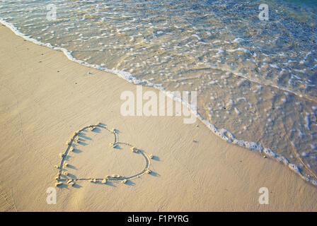 Cuore disegnato nella sabbia. Sfondo di spiaggia. Vista superiore Foto Stock