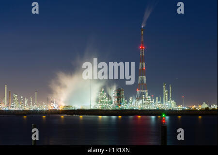 Vista sul fiume Schelda in Anversa, Belgio per una grande raffineria di petrolio con flair stack e notte cielo blu, illuminazione e st Foto Stock