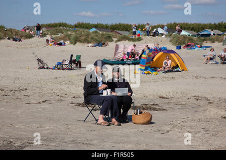 Wittering, Sussex, Regno Unito. 6 Settembre, 2015. Tè per due sulla spiaggia in West Wittering, West Sussex, Regno Unito 06.09.2015 un paio di godere del bel tempo in un modo molto bagnato Autunno in tutto il Regno Unito. Domenica ha portato buone temperature e cielo blu in tutta l'Inghilterra meridionale portando decine di persone per la spiaggia di West Wittering nelle vicinanze del Chichester. Credito: Jeff Gilbert/Alamy Live News Foto Stock