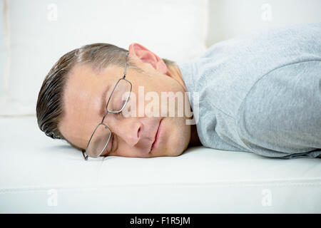 L'uomo prendendo un pisolino sul divano Foto Stock