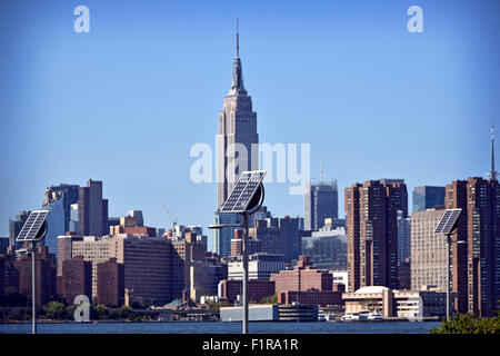 Pannelli solari in East River State Park a Brooklyn, NY con una vista di Manhattan e l'Empire State building in background. Foto Stock