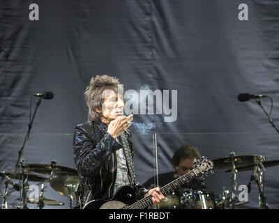 Ewhurst, Surrey, Inghilterra. 5 settembre 2015. Ronnie Wood fuma una sigaretta come egli si esibisce dal vivo sul palco e viene inghirlandato in fumo. Le facce reunion: Rod Stewart, Ronnie Wood e Kenney Jones, i sopravvissuti delle facce, eseguita per la prima volta insieme in oltre quaranta anni in un concerto dal vivo presso la struttura Hurtwood Park Polo Club, Ewhurst, Surrey, Inghilterra, come parte del Rock 'n' evento di potenza a sostegno del cancro della prostata UK. Credito: Graham Prentice/Alamy Live News Foto Stock