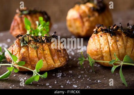 Hasselback patate al timo, origano e sale Foto Stock