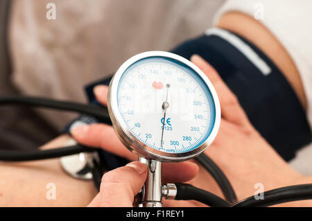 Medico donna utilizza uno sfigmomanometro Foto Stock