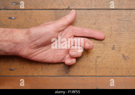 Old man mano gesticolando su uno sfondo di legno Foto Stock