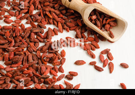 Goji berry essiccato in un piatto con il cucchiaio, closeup sfondo Foto Stock