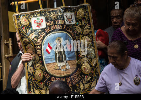New York, Stati Uniti. 06 Sep, 2015. Un membro di una delle confraternite marciando con la processione porta un banner dalla chiesa. La congregazione della chiesa dei Santi Innocenti terrà la sua annuale street processione in onore del santo peruviano, San Martin de Porres -- il santo patrono di interracial armonia. Credito: Albin Lohr-Jones/Pacific Press/Alamy Live News Foto Stock