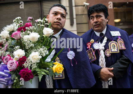 New York, Stati Uniti. 06 Sep, 2015. Un membro della confraternita " El Señor de los Milagros' detiene un mazzo di fiori alla processione continua lungo la West 37th Street. La congregazione della chiesa dei Santi Innocenti terrà la sua annuale street processione in onore del santo peruviano, San Martin de Porres -- il santo patrono di interracial armonia. Credito: Albin Lohr-Jones/Pacific Press/Alamy Live News Foto Stock