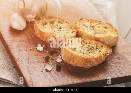 Crostini con aglio e spezie su tavola di legno Foto Stock