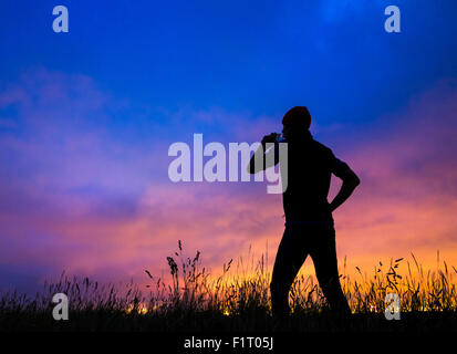 Cowpen Bewley parco boschivo, Billingham, Regno Unito. Il 7 settembre, 2015. Meteo: jogging sulla collina nel parco boschivo stagliano glow da Teesside's industrial skyline di pre alba luce il lunedì mattina. Credito: Alan Dawson News/Alamy Live News Foto Stock