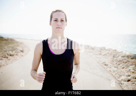 Donna in capi di abbigliamento sportivi jogging sul lungomare Via Foto Stock