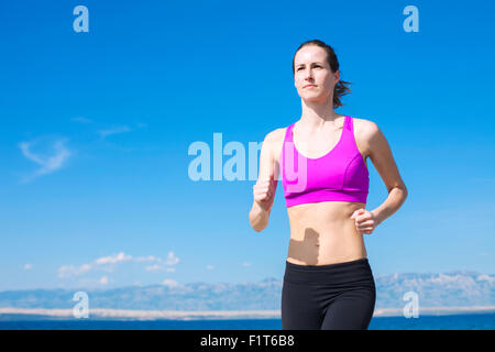 Giovane donna in esecuzione sul percorso fronte mare Foto Stock