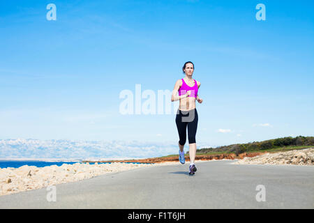 Giovane donna in esecuzione sul percorso fronte mare Foto Stock