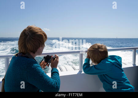 Madre e figlio di scattare fotografie da una barca Foto Stock