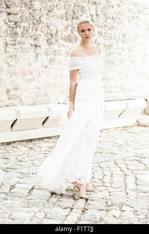 Sposa abiti da sposa si erge di fronte alla chiesa Foto Stock