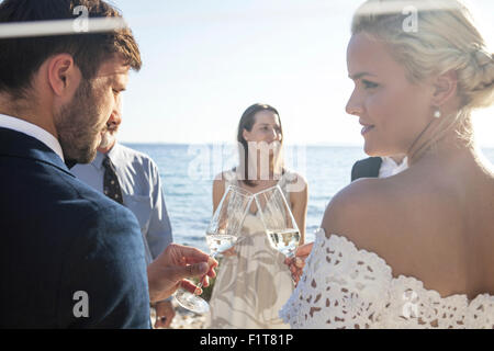 Sposa e lo sposo bevendo champagne sul ricevimento di nozze Foto Stock