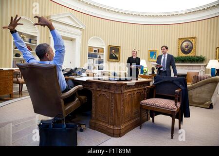 Stati Uniti Il presidente Barack Obama gesti come egli incontra Anita Breckenridge, Vice Capo del personale per le operazioni e Chase Cushman, direttore di Pianificazione e avanzare nell'Ufficio Ovale della Casa Bianca Aprile 17, 2015 a Washington, DC. Foto Stock