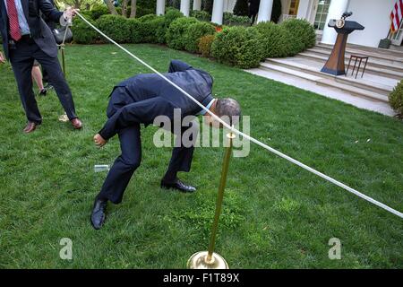 Stati Uniti Il presidente Barack Obama si inerpica sotto una corda linea come parte dopo il saluto di ospiti durante un Medicare sostenibile tasso di crescita la reception nel Giardino delle Rose della Casa Bianca Aprile 21, 2015 a Washington, DC. Foto Stock