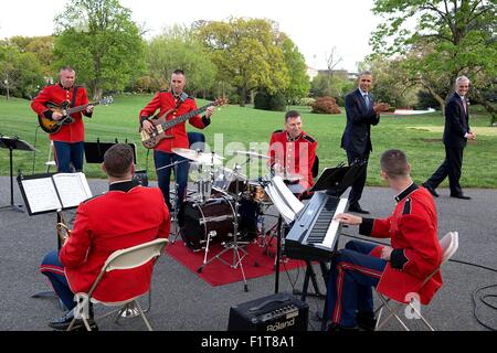 Stati Uniti Il presidente Barack Obama e il capo del personale Denis McDonough applaudire il U.S. Marine Jazz Band Combo riproduzione durante un ricevimento per medicare la crescita sostenibile di velocità nel Giardino delle Rose della Casa Bianca Aprile 21, 2015 a Washington, DC. Foto Stock