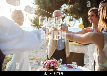 Bere champagne al ricevimento di nozze sulla spiaggia Foto Stock