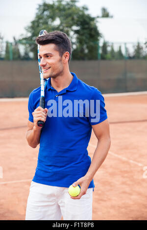 Ritratto di un felice tennista in piedi all'aperto Foto Stock