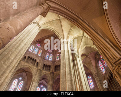 Svettanti colonne e incandescente Windows. Le enormi colonne di pietra della cattedrale portano l'occhio fino al tetto e il vetro macchiato Foto Stock